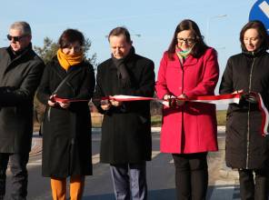 Symboliczne otwarcie drogi - zdjęcie przedstawia uczestników wydarzenia przecinających wstęgę