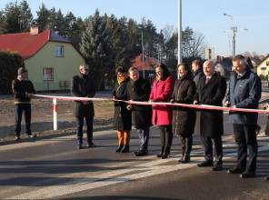 Symboliczne otwarcie drogi - zdjęcie przedstawia uczestników wydarzenia przecinających wstęgę