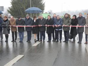 Symboliczne otwarcie drogi - zdjęcie przedstawia uczestników wydarzenia przecinających wstęgę