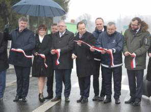 Symboliczne otwarcie drogi - zdjęcie przedstawia uczestników wydarzenia przecinających wstęgę