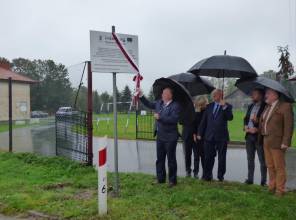 Symboliczne odsłonięcie tablicy informującej o inwestycji - zdjęcie przedstawia uczestników wydarzenia