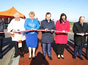Symboliczne otwarcie drogi - zdjęcie przedstawia uczestników wydarzenia przecinających wstęgę
