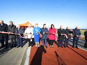 Symboliczne otwarcie drogi - zdjęcie przedstawia uczestników wydarzenia przecinających wstęgę