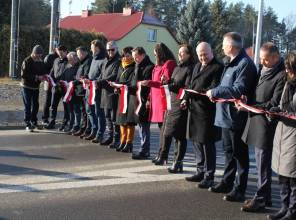 Symboliczne otwarcie drogi - zdjęcie przedstawia uczestników wydarzenia przecinających wstęgę