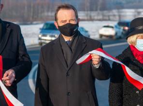 Symboliczne otwarcie drogi - zdjęcie przedstawia uczestników wydarzenia przecinających wstęgę