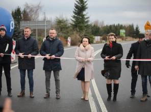 Symboliczne otwarcie drogi - zdjęcie przedstawia uczestników wydarzenia przecinających wstęgę
