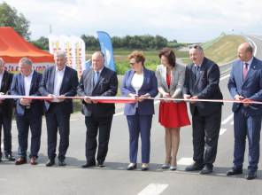 Symboliczne otwarcie drogi - zdjęcie przedstawia uczestników wydarzenia przecinających wstęgę
