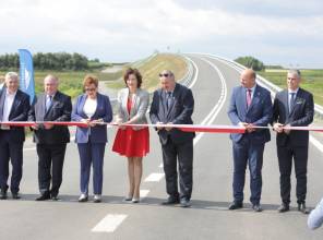 Symboliczne otwarcie drogi - zdjęcie przedstawia uczestników wydarzenia przecinających wstęgę