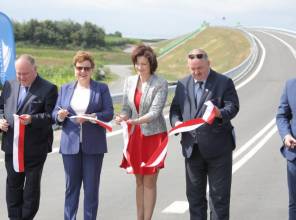 Symboliczne otwarcie drogi - zdjęcie przedstawia uczestników wydarzenia przecinających wstęgę