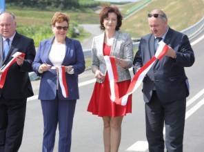 Symboliczne otwarcie drogi - zdjęcie przedstawia uczestników wydarzenia przecinających wstęgę
