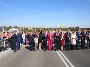 Zdjęcie przedstawia uczestników wydarzenia przecinających wstęgę