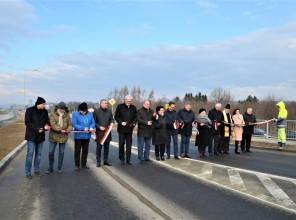 Symboliczne otwarcie drogi - zdjęcie przedstawia uczestników wydarzenia przecinających wstęgę
