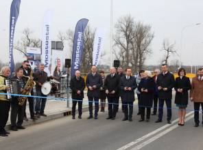 Symboliczne otwarcie drogi - zdjęcie przedstawia uczestników wydarzenia przecinających wstęgę